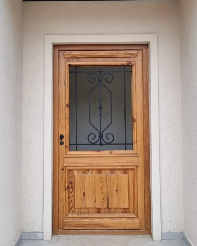 Single colonial door with an iron grille on a white facade
