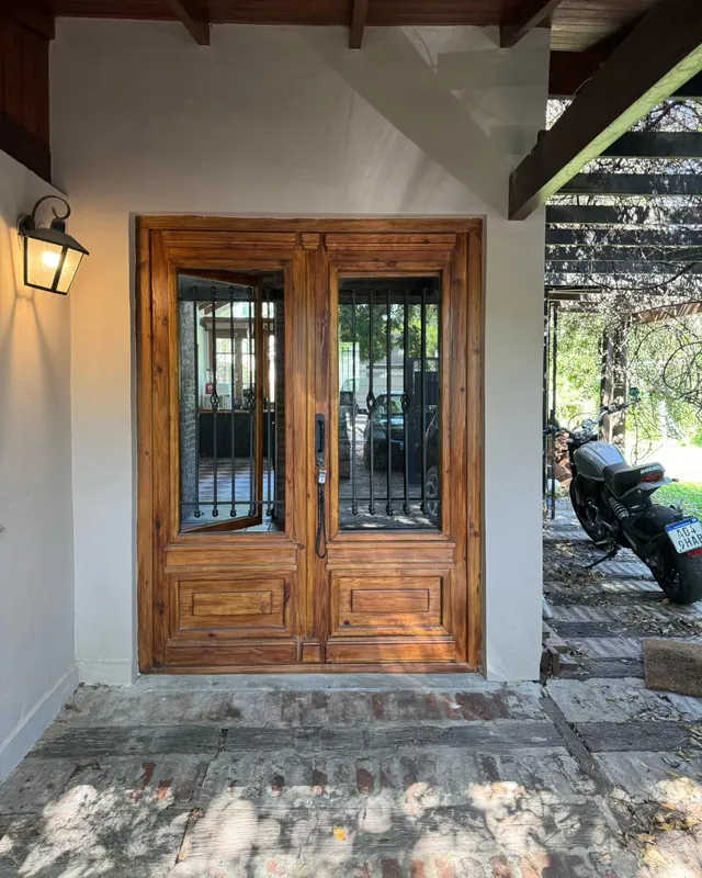 Double colonial door with iron grilles under a pergola
