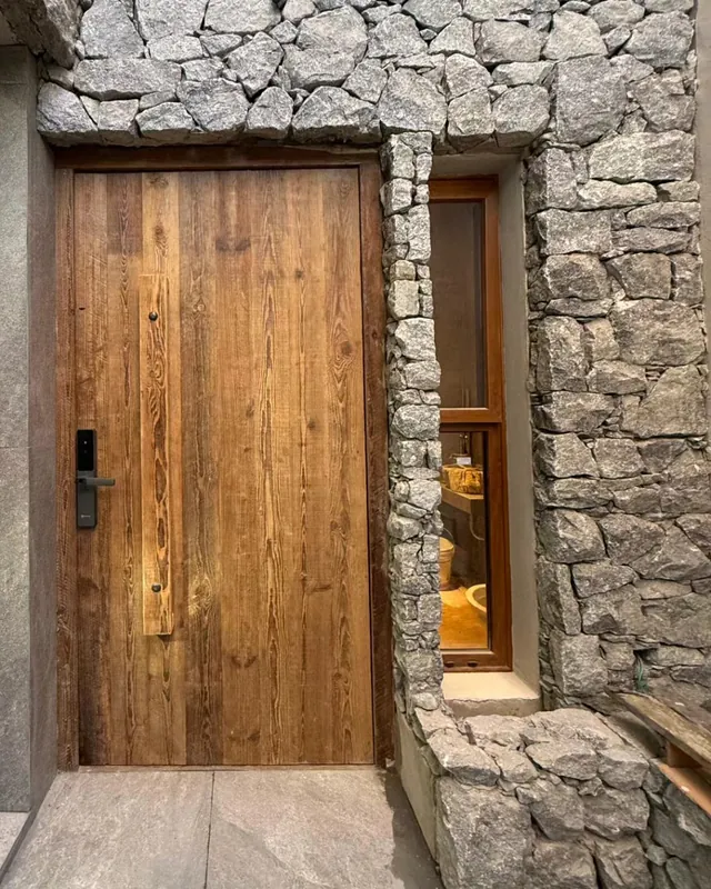 Full-plank heart pine door installed between dry-stone walls